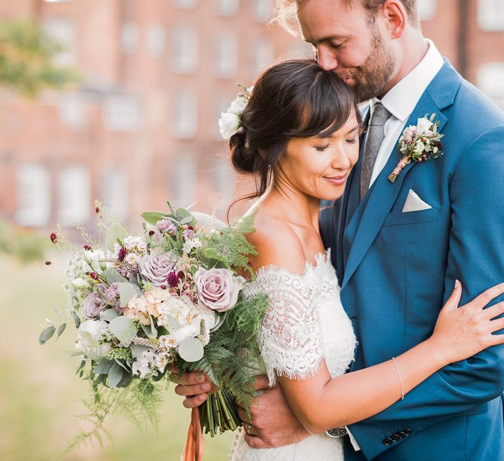 Bride in Lace Watters Dress with Bardot Neckline and Buttons Down Back | Bridal Up Do | Groom in Royal Blue Three-Piece Suit from Moss Bros. with Silver Tie and Pocket Square from T.M.Lewin | Bridal Bouquet of Dusky Pink Roses, White Peonies, Sweetpeas, Coffee-Coloured Phlox and Foliage Tied with Cappuccino Silk Ribbon | Smoke Bombs and Chinese Paper Fans Backdrop with Bride in Bardot Dress | Twig &amp; Vine Photography