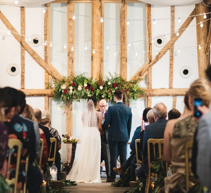 Bride and Groom During Wedding Ceremony in Barn Venue