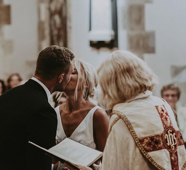 Bride and Groom Kissing at the Altar