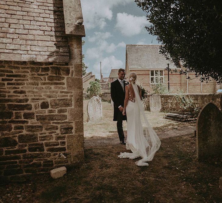 Bride in Rime Arodaky Wedding Dress and Groom in Traditional Morning Suit Outside the Church