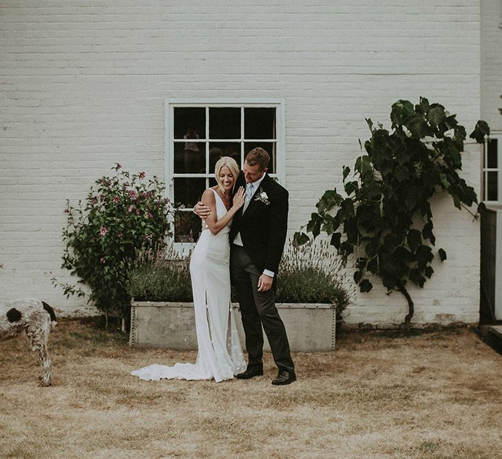 Bride in Rime Arodaky Wedding Dress and Groom in Morning Suit Portrait with Their Dog