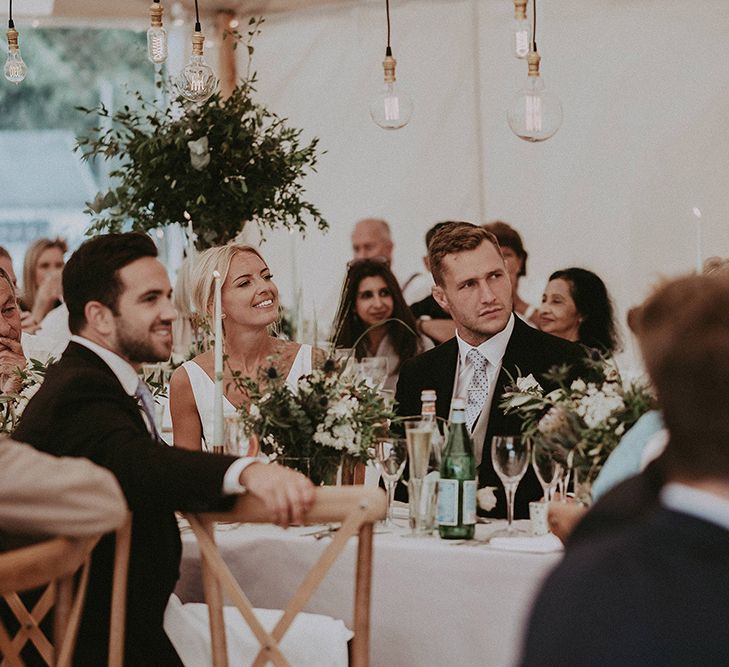 Bride and Groom Enjoying The Speeches During the Sperry Tent Reception