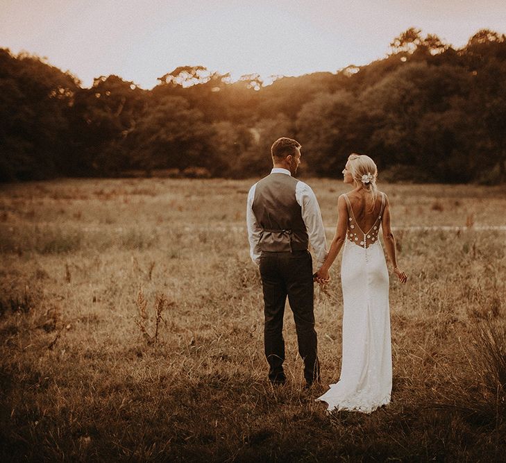 Bride in Rime Arodaky Wedding Dress with Lace Back and Groom in Morning Suit  Enjoying a Stroll