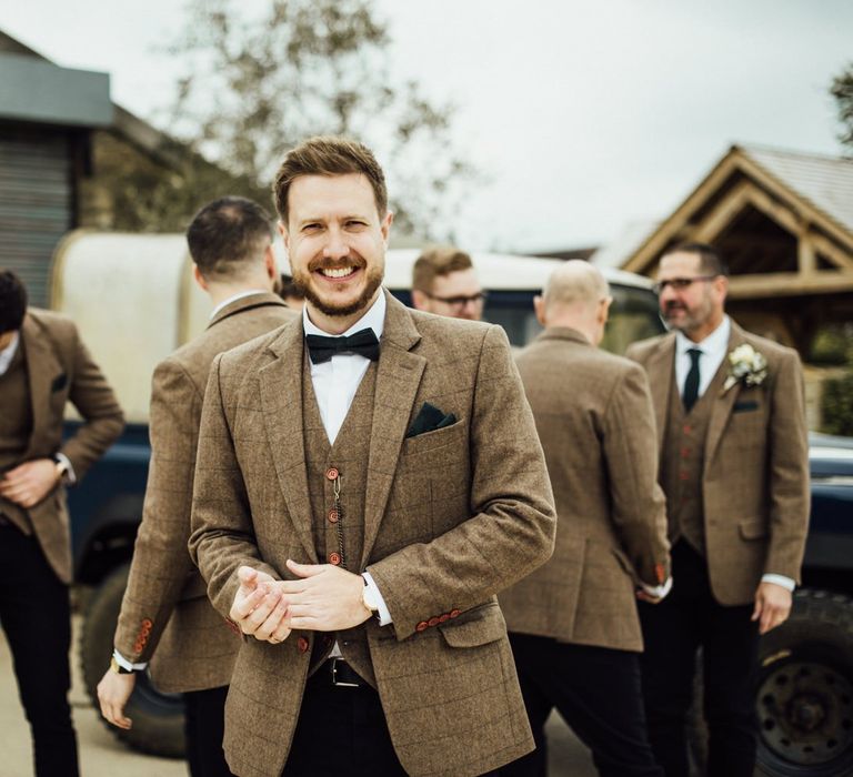 Groom in tweed suit with bowtie for Oxfordshire barn wedding