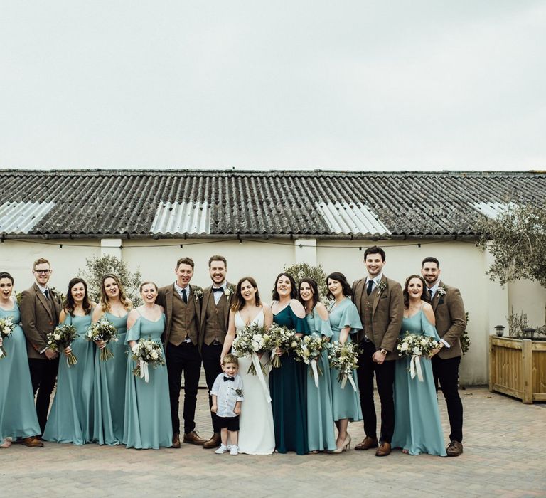 Blue Rewritten bridesmaid dresses with groomsmen in tweed suits