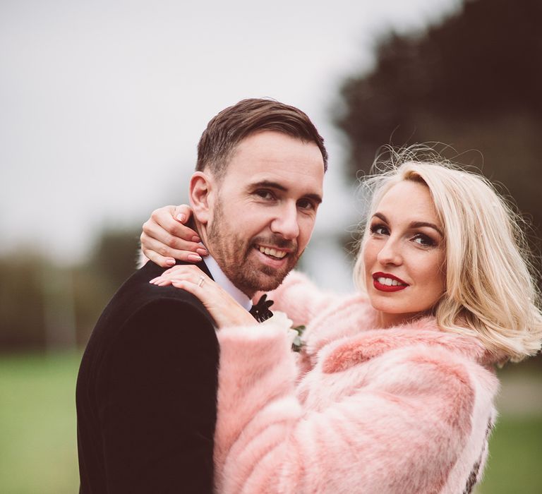 Bride in Organza Justin Alexander Gown &amp; Blush Pink Faux Fur Coverup | Groom in Black Tie Suit | Blush Pink &amp; Red, Christmas, Winter Wedding at Coltsfoot Country Retreat | Lemonade Pictures