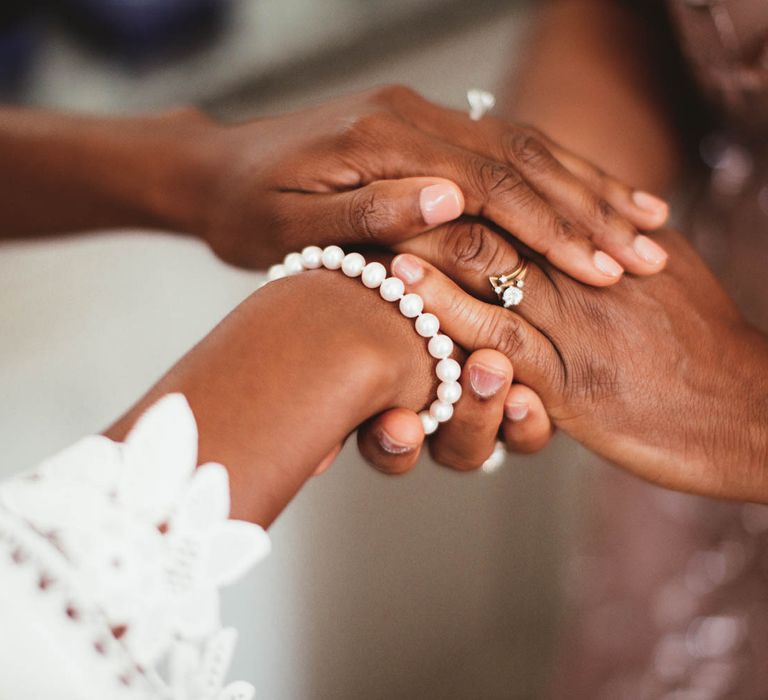 Bride and mother of the bride holding hands on the wedding morning