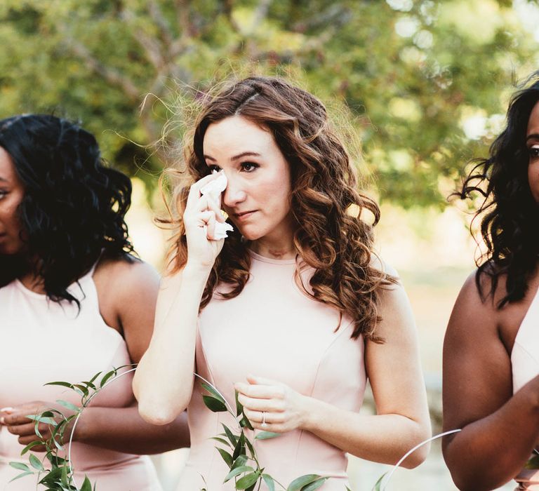 Emotional bridal party in pink bridesmaid dresses