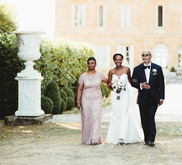 Mother and Father of the bride walking their daughter down the aisle