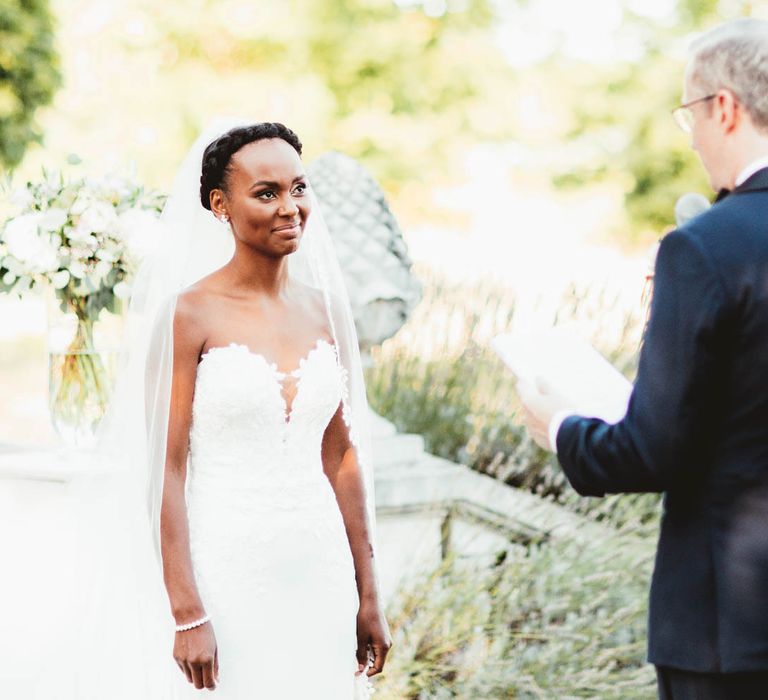 Bride in strapless Pronovias wedding dress and Groom in Tuxedo exchanging vows