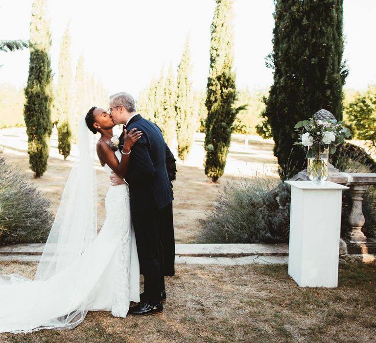 Bride and groom kissing at the altar at their Chateau La Durantie outdoor wedding ceremony