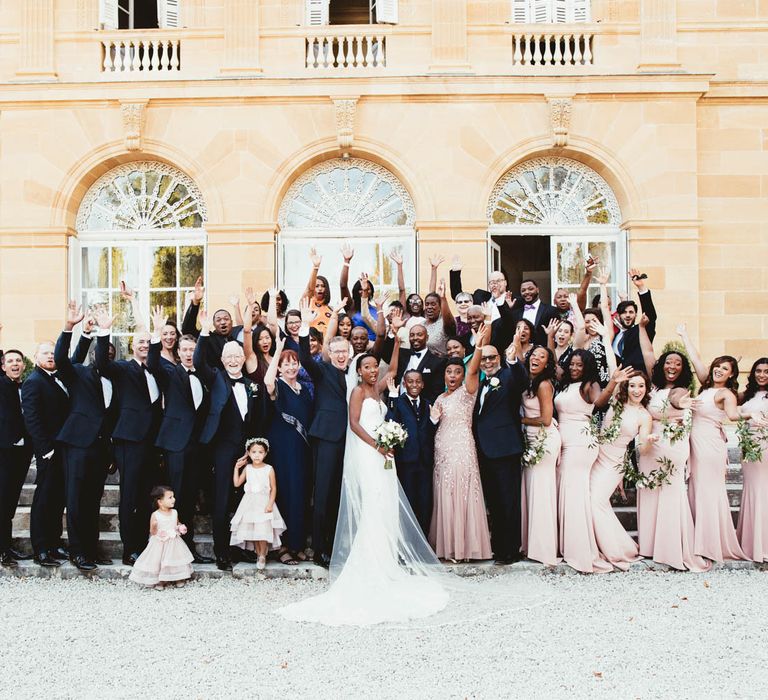 Group wedding guests portrait with pink bridesmaid dresses and tuxedos