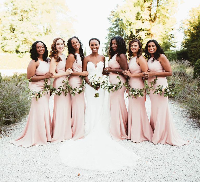 Bridal party portrait with pink bridesmaid dresses and Pronovias wedding dress