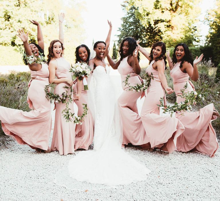 Fun bridal party portrait with pink bridesmaid dresses and strapless wedding dress