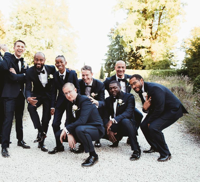 Groomsmen portrait in tuxedos for destination wedding with pink bridesmaid dresses