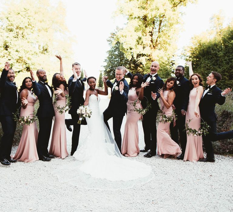 Wedding party portrait with Pronovias wedding dress, pink bridesmaid dresses and tuxedos