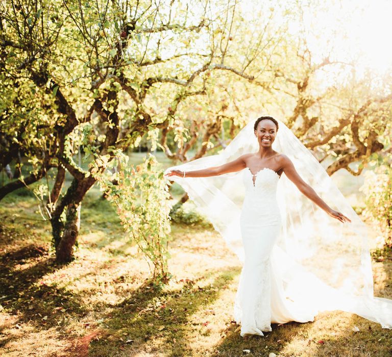 Black bride in strapless Pronovias wedding dress and veil for destination wedding with pink bridesmaid dresses