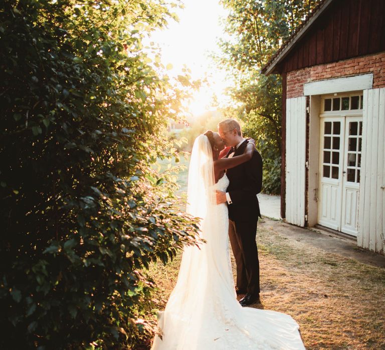 Bride and groom kissing during sunset