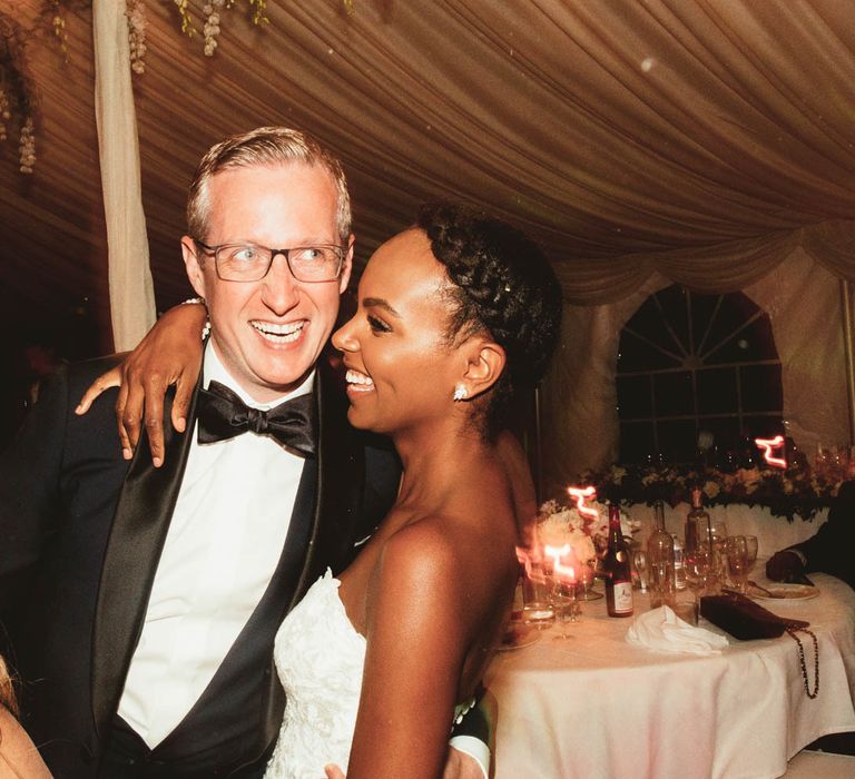 Bride and Groom laughing and hugging on the dance floor at their Chateau La Durantie marquee reception