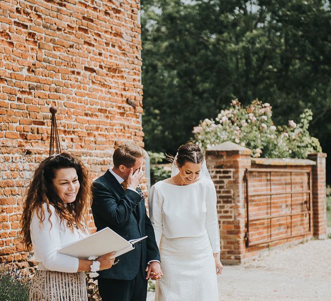 Bride in Halfpenny London Separates of Laura Top with Cowl Back and Long Sleeves, Silk Cami and Laser Cut Palm Skirt | Groom in Navy Tweed Suit by Walker Slater with Yellow Tie and Patterned Pocket Square | Outdoor Wedding Ceremony at Abbey Hall Creative Space | 'Frida Kahlo' Flower Crown, Halfpenny London Bridal Separates and Colourful Bouquets with Peonies for Suffolk Wedding | From The Smiths Photography