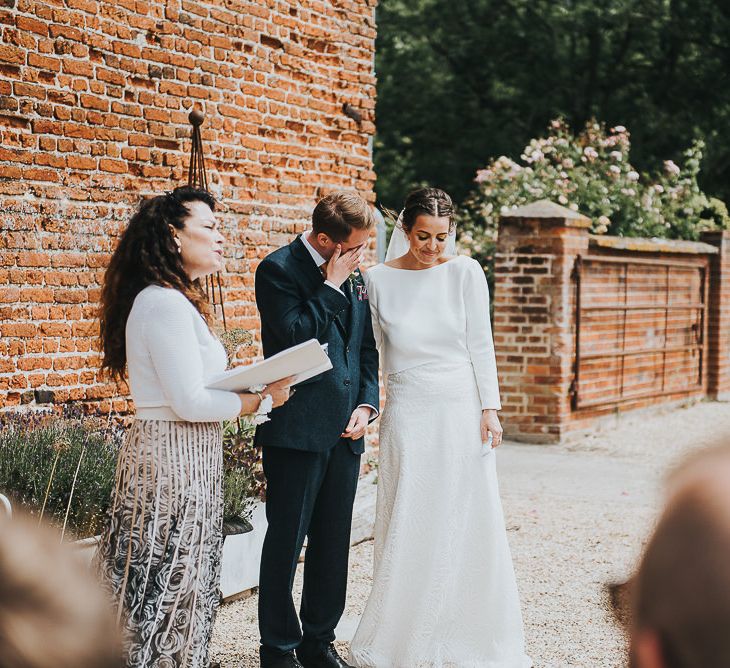 Bride in Halfpenny London Separates of Laura Top with Cowl Back and Long Sleeves, Silk Cami and Laser Cut Palm Skirt | Groom in Navy Tweed Suit by Walker Slater with Yellow Tie and Patterned Pocket Square | Outdoor Wedding Ceremony at Abbey Hall Creative Space | 'Frida Kahlo' Flower Crown, Halfpenny London Bridal Separates and Colourful Bouquets with Peonies for Suffolk Wedding | From The Smiths Photography