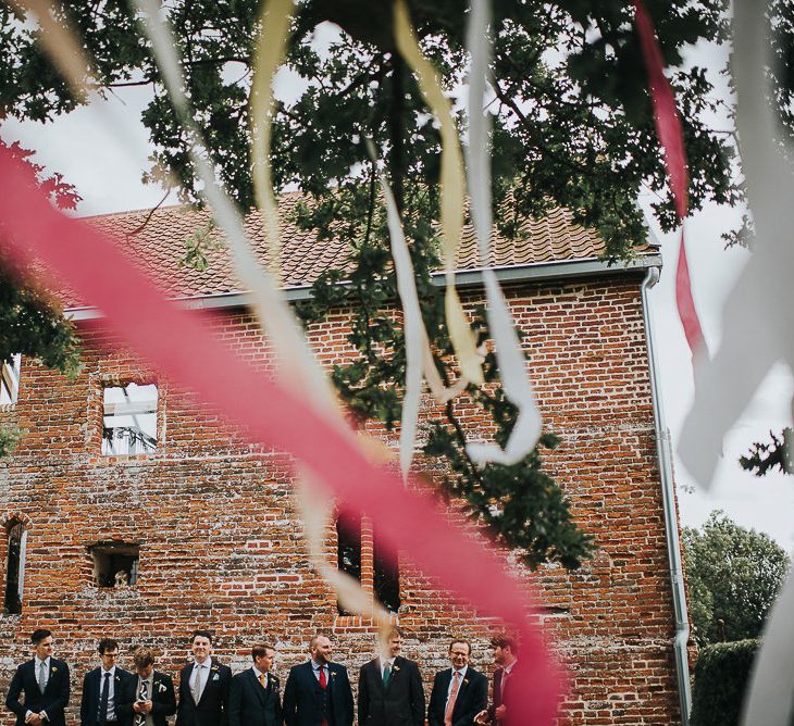 Groom in Navy Tweed Suit by Walker Slater with Yellow Tie and Patterned Pocket Square | Groomsmen in Mismatched Navy Suits | Red, Yellow and White Ribbons | Abbey Hall Creative Space Wedding Venue | 'Frida Kahlo' Flower Crown, Halfpenny London Bridal Separates and Colourful Bouquets with Peonies for Suffolk Wedding | From The Smiths Photography