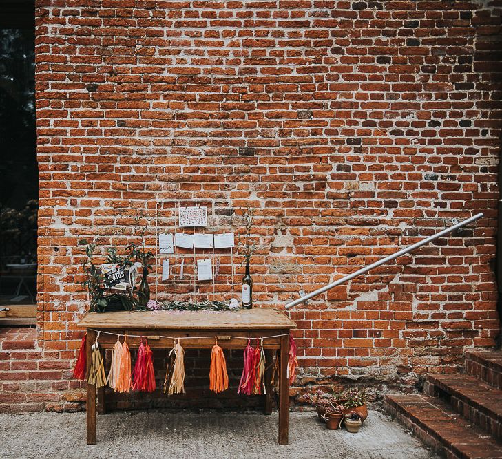 Metal Frame Table Plan | Rustic Wooden Bureau | Red, Orange and Gold Tassels | Cards Box Decorated with Foliage | 'Frida Kahlo' Flower Crown, Halfpenny London Bridal Separates and Colourful Bouquets with Peonies for Suffolk Wedding | From The Smiths Photography