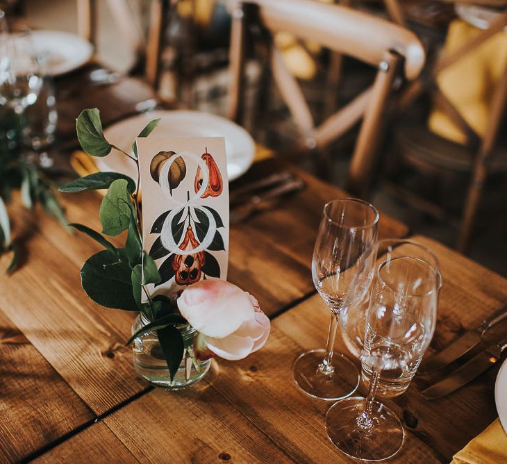 Table Number Card | Long Wooden Banquet Tables | Yellow Napkins | Pink, Orange and Yellow Table Flowers with Foliage | Wedding Reception at Abbey Hall Creative Space | 'Frida Kahlo' Flower Crown, Halfpenny London Bridal Separates and Colourful Bouquets with Peonies for Suffolk Wedding | From The Smiths Photography