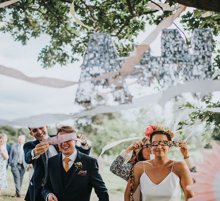 Bride in Halfpenny London Separates of Laura Top with Cowl Back and Long Sleeves, Silk Cami and Laser Cut Palm Skirt | Flower Crown with Pink Peony | Groom in Navy Tweed Suit by Walker Slater with Yellow Tie and Patterned Pocket Square | Piñata | 'Frida Kahlo' Flower Crown, Halfpenny London Bridal Separates and Colourful Bouquets with Peonies for Suffolk Wedding | From The Smiths Photography