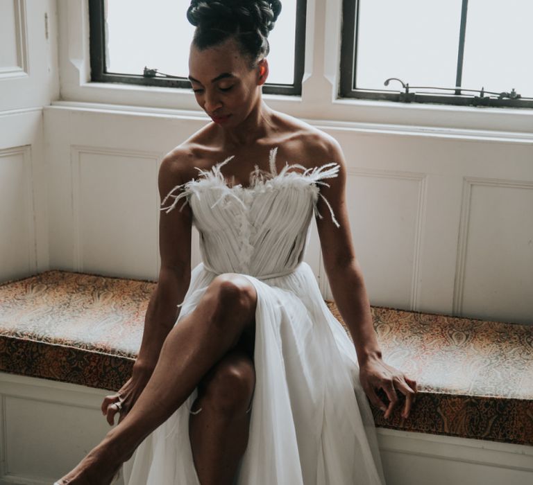 Black bride in Mira Zwillinger wedding dress with feathers