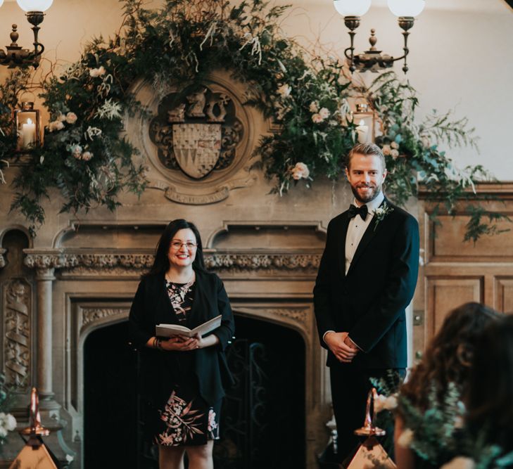 Groom in tuxedo standing at the altar of The Elvetham wedding venue