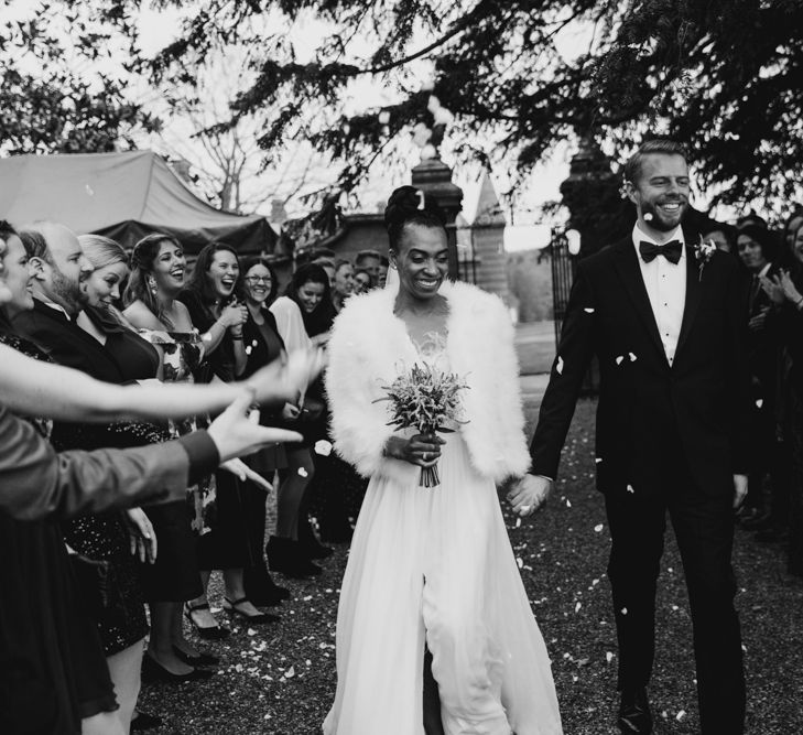 Confetti moment with bride in faux fur coverup