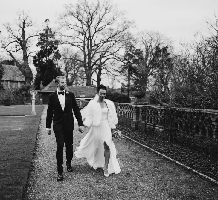 stylish bride and groom walking through the grounds at  The Elvetham wedding venue