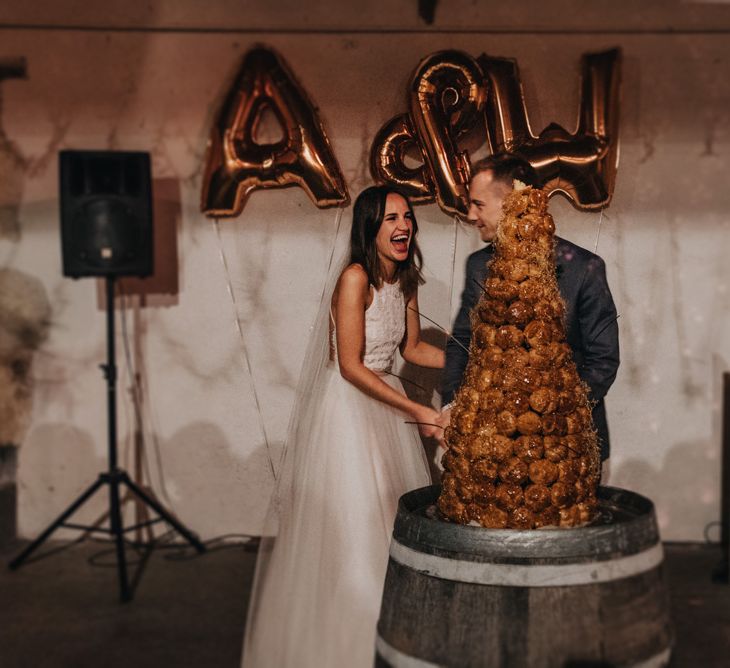 Bride and Groom cutting the Cake with Copper Foil Balloons Backdrop