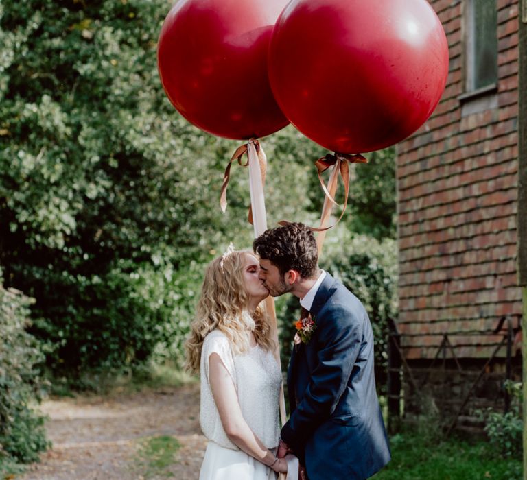 Bride and Groom Kissing Holding Extra Large Balloons