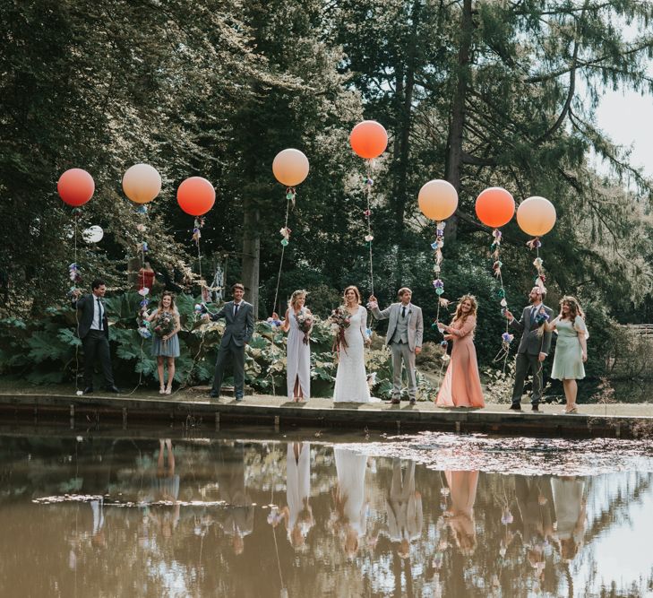 Wedding Party Portrait on the Rivers Edge with Everyone Holding a Giant Balloon on a String