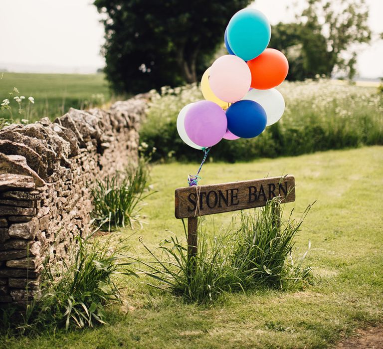 Colourful Balloons Tied to the Wedding Venue Entrance Sign