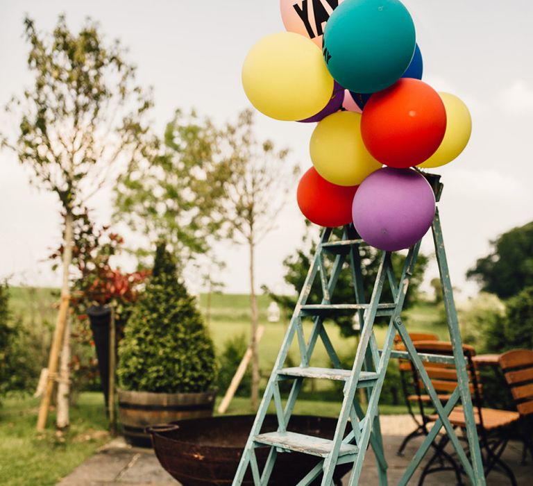 Colourful Balloons with YAY Slogan Balloon Tied to Vintage Step Ladders