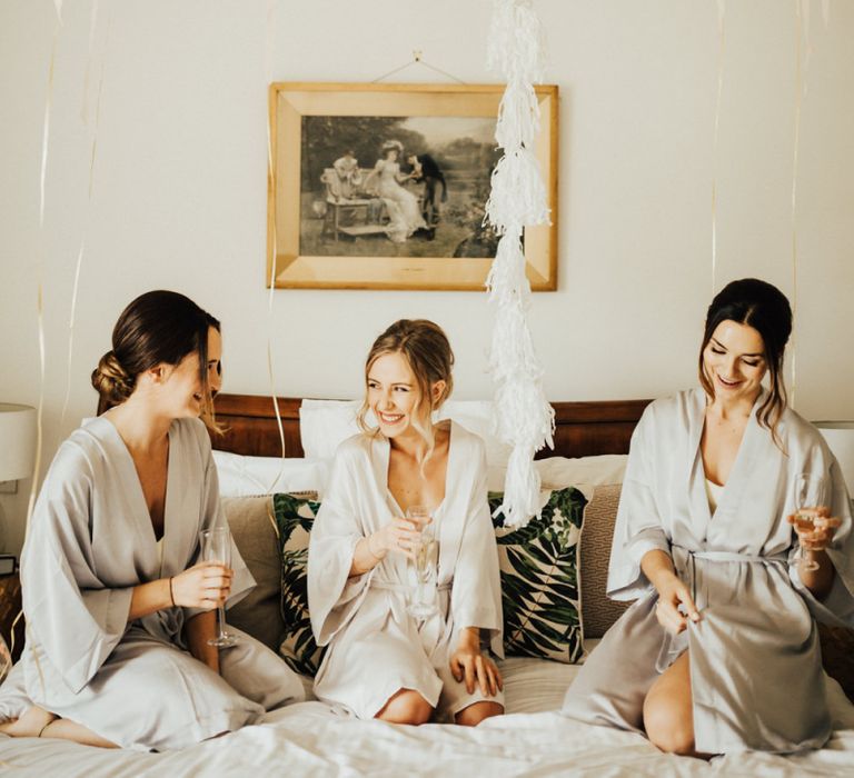 Bride and Bridesmaids on Wedding Morning with Oversized White Balloon with Tassels and Pink, Gold and White Confetti Balloons lining the ceiling