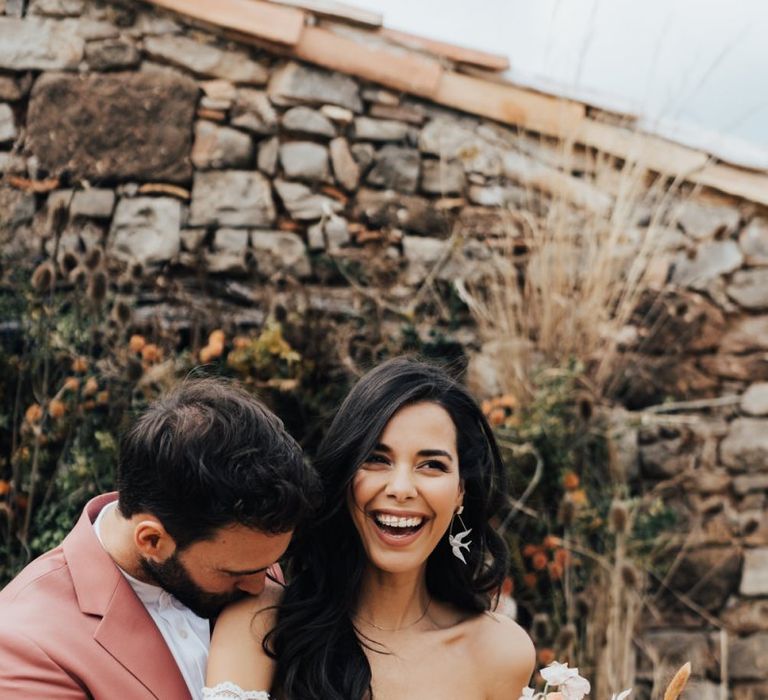 Groom Kissing his Brides Should in Bardot Wedding Dress