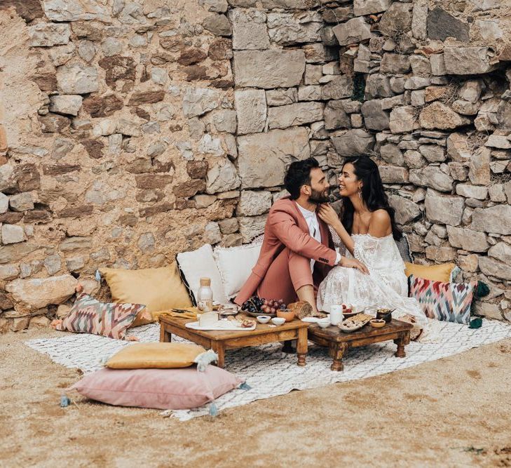 Bride and Groom Enjoying an Intimate Grazing Table on Como Cushions and Blankets