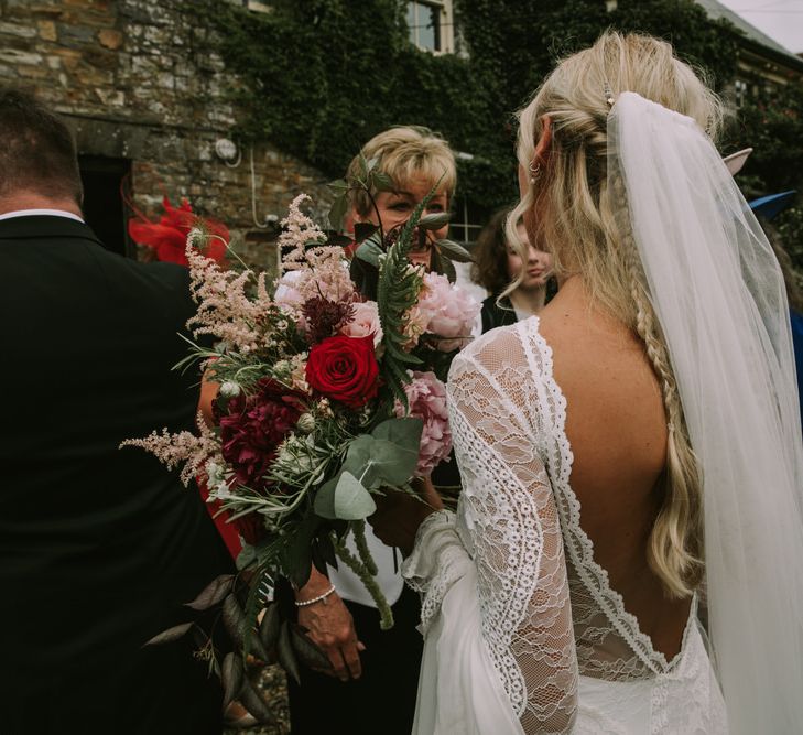 Bride in Grace Loves Lace Inca Gown with Boat Neck, Lace Sleeves and Low Back | Personalised Embroidered Veil by Daisy Sheldon | Aurora Hair Comb by Tilly Thomas Lux  | Bridal Bouquet of Burgundy and Blush Flowers with Foliage | Mykonos Rewritten Bridesmaid Dresses for an Epic Clifftop Coastal Wedding | Nic Ford Photography