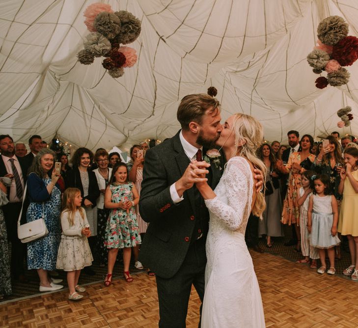 Bride in Grace Loves Lace Inca Gown with Boat Neck, Lace Sleeves and Low Back | Groom in Three-Piece Grey Herringbone Suit with Burgundy Tie and Buttons | Blush Buttonhole | Marquee with Draped Ceiling at The Druidstone | Grey, Blush and Burgundy Pom Poms | Fairy Lights | Mykonos Rewritten Bridesmaid Dresses for an Epic Clifftop Coastal Wedding | Nic Ford Photography