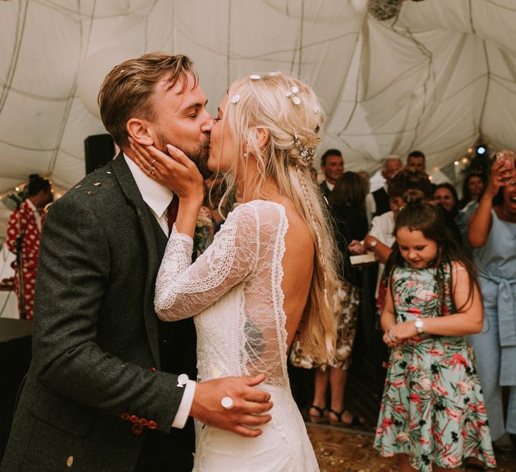 Bride in Grace Loves Lace Inca Gown with Boat Neck, Lace Sleeves and Low Back | Groom in Three-Piece Grey Herringbone Suit with Burgundy Tie and Buttons | Confetti Cannon | First Dance at The Druidstone | Mykonos Rewritten Bridesmaid Dresses for an Epic Clifftop Coastal Wedding | Nic Ford Photography