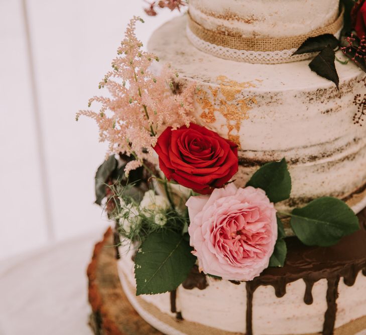 Three-Tier Semi-Naked Wedding Cake with Chocolate Drippy Icing, Gold Leaf, Hessian Ribbon and Red Roses | Mykonos Rewritten Bridesmaid Dresses for an Epic Clifftop Coastal Wedding | Nic Ford Photography