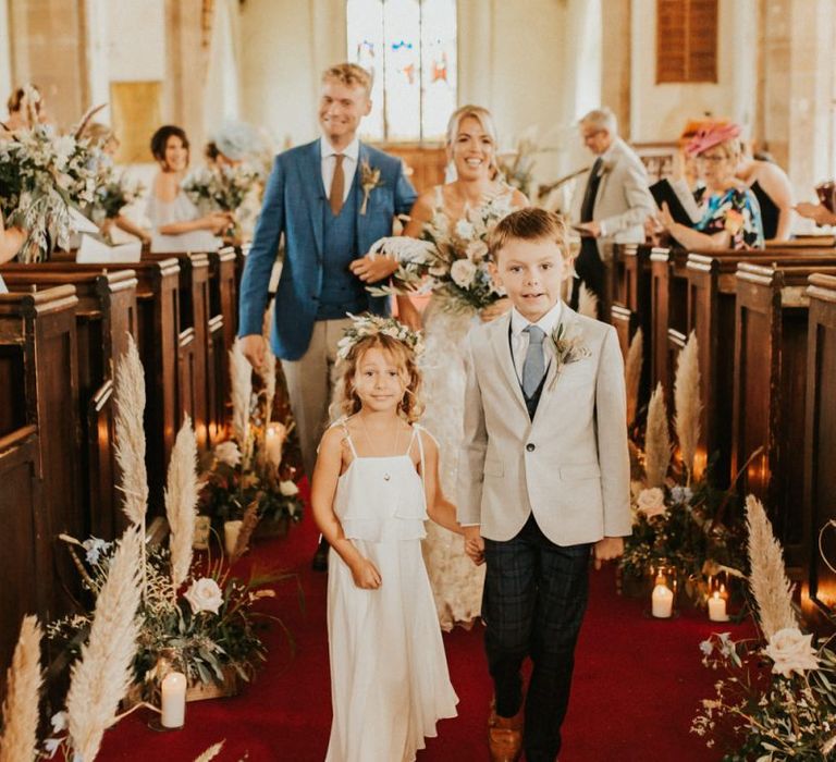 Flower girl and page boy walking down the aisle