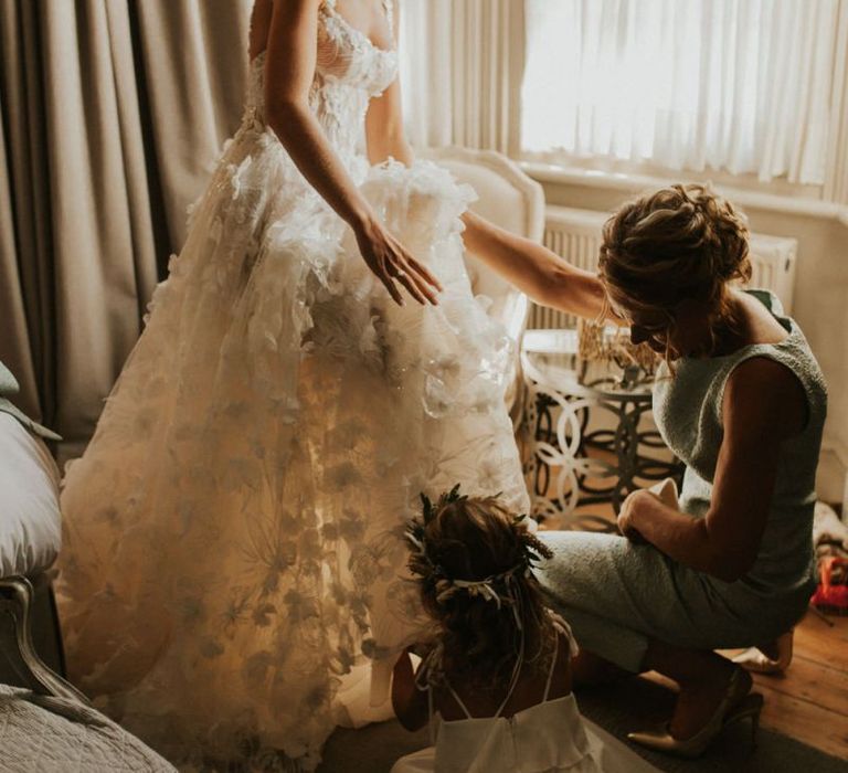 Bride in Galia Lahav wedding dress putting on her wedding shoes