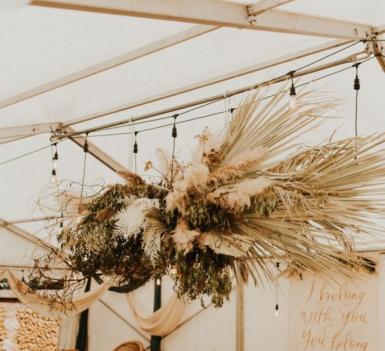 Marquee wedding reception with dried flower installation