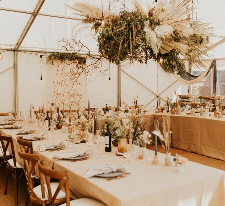 August 2020 wedding reception in a marquee with boho wedding flowers and decor