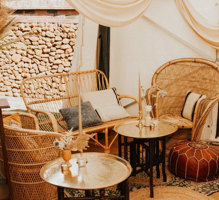 Boho seating corner with peacock chairs, pouffes and mats